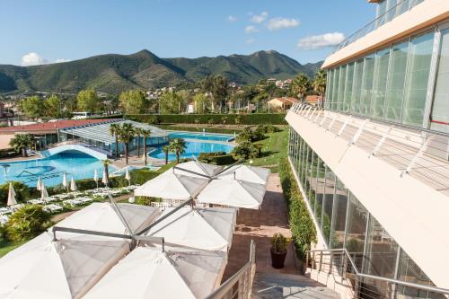 eine Aussicht über den Pool in einem Resort mit Sonnenschirmen in der Unterkunft Loano 2 Village in Loano