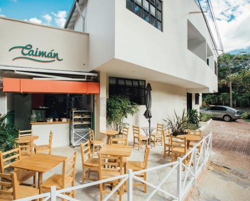 a restaurant with wooden tables and chairs in front of a building at 574 Hotel in Medellín