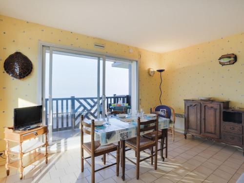 a dining room with a table with chairs and a television at Apartment Cabourg Beach by Interhome in Cabourg