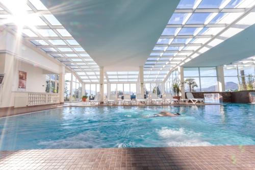 a swimming pool in a building with a glass ceiling at Hotel Terme Leonardo in Abano Terme
