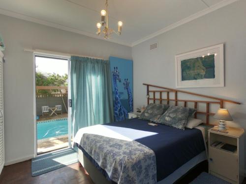 a bedroom with a bed and a swimming pool at Leo's Den in Fish hoek