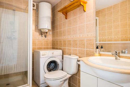 a bathroom with a toilet and a sink and a washing machine at Guayero in Los Cristianos