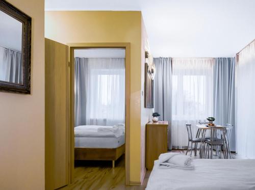 a room with two beds and a table and a mirror at Lazur Apartamenty in Świnoujście