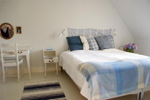 1 dormitorio con 1 cama, 1 mesa y 1 silla en Svanebäcks gård en Viken
