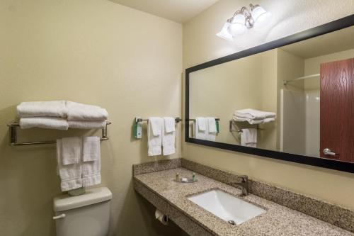 a bathroom with a sink and a mirror at Cobblestone Hotel & Suites - Torrington in Torrington
