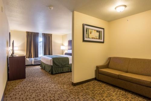 a hotel room with a bed and a couch at Cobblestone Hotel & Suites - Torrington in Torrington
