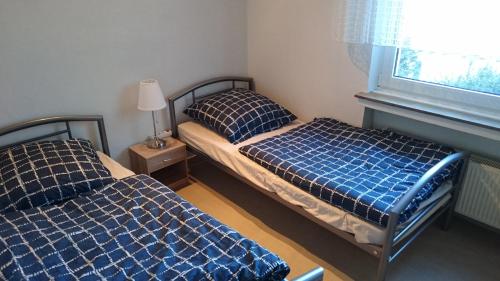 two beds in a small bedroom with a window at Ferienwohnung Berger in Greven