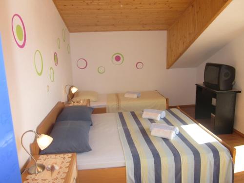 Un dormitorio pequeño con una cama y un televisor. en APARTMANI KREŠIĆ 1 HVAR, en Hvar