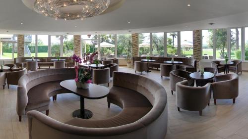 a restaurant with couches and tables and chairs at Hotel Terme Leonardo in Abano Terme
