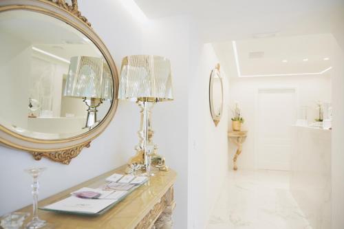 a bathroom with a mirror and a table with a lamp at Palazzo Marletta Luxury House Hotel in Catania