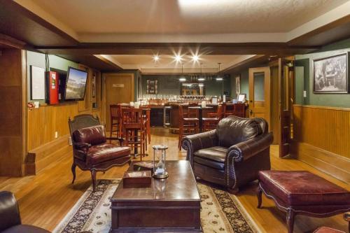 a living room with leather furniture and a bar at Patterson Inn in Denver