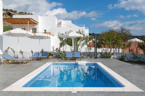 a swimming pool in front of a white house at Milos Villas Complex in Pefki Rhodes