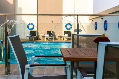 - une piscine avec une table et des chaises dans un bâtiment dans l'établissement Hafawah Suites, à Médine