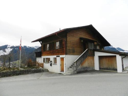 uma casa de madeira com garagem em frente em Apartment Fluehüsli by Interhome em Gstaad