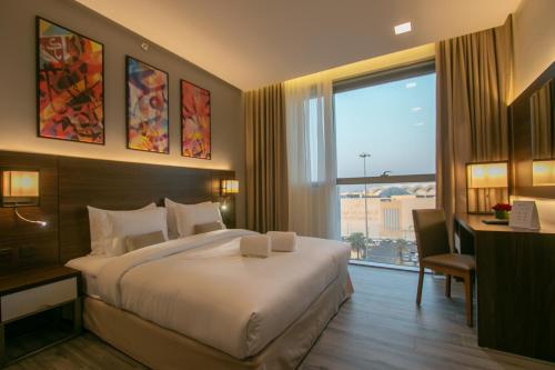 a hotel room with a bed and a large window at Hafawah Suites in Al Madinah