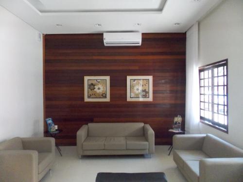 a living room with two couches and a wooden wall at Hotel Mattes in Joinville