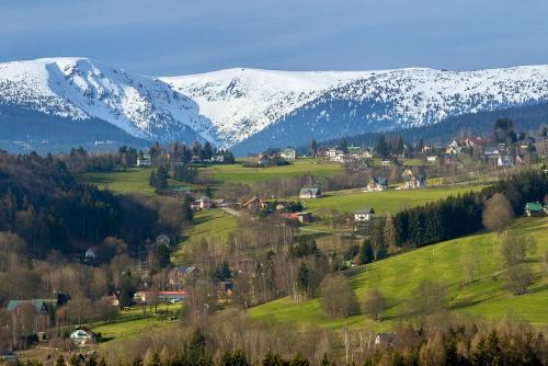 a small town in a valley with snow covered mountains at ProFamily Hotel TOP Benecko in Benecko