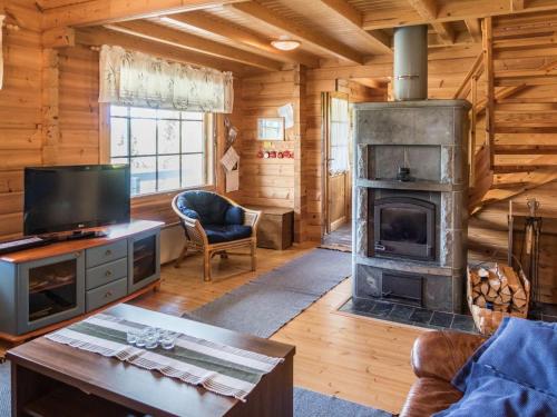 ein Wohnzimmer mit Kamin in einer Blockhütte in der Unterkunft Holiday Home Värikatti by Interhome in Vuokatti