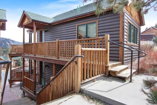 a log cabin with a wooden deck and stairs at Chiefs Head Peak 21B Condo in Estes Park