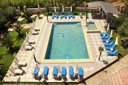 a pool with chairs, tables, and umbrellas at Hotel Stefani in Sarti