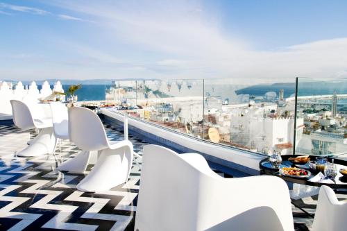 a balcony with white chairs and a view of the city at Riad Dar Saba - Saba's House in Tangier