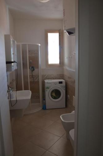 een badkamer met een wasmachine en een wastafel bij Appartamento 5 - Via Carlo Alberto n 26 - Immobileuro srl in Castelsardo