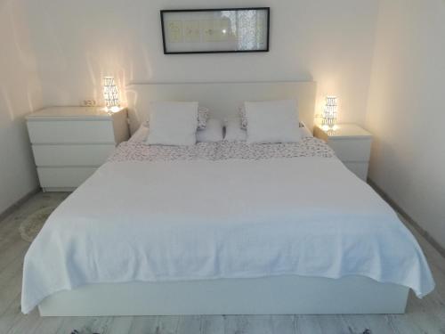 a bedroom with a white bed with two night stands at Apartma Neža in Bled