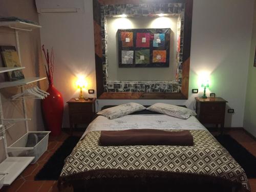 a bedroom with a bed and two lamps and a mirror at B&B Filomena in Santa Giusta