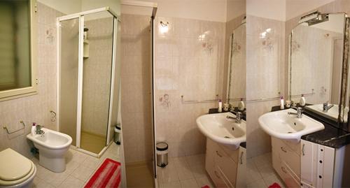 uma casa de banho com 2 lavatórios, um chuveiro e um WC. em B&B Angolo Di Paradiso em Pellaro