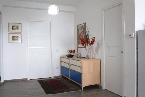 a room with a dresser with a vase of flowers on it at Marina Holiday Home in Pizzo
