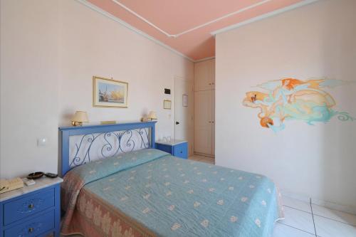 a bedroom with a bed and a painting on the wall at Villa Ianthia in Galaxidhion
