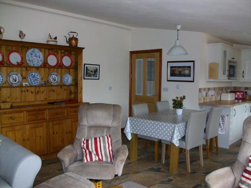 a kitchen and dining room with a table and chairs at The Old Cowstall in Somerton