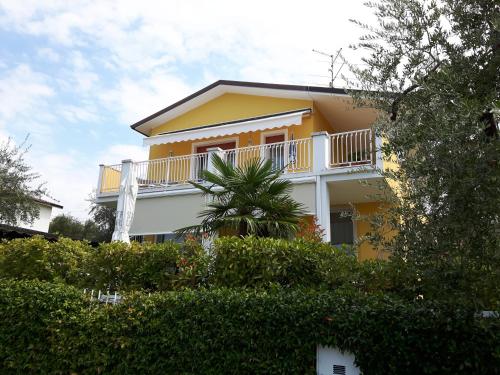 a yellow and white house with a balcony at Villa Mimosa in Bardolino