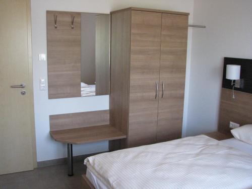 ein Schlafzimmer mit einem Bett und eine Kommode mit einem Spiegel in der Unterkunft Karpfenhaus Feuchtwangen in Feuchtwangen