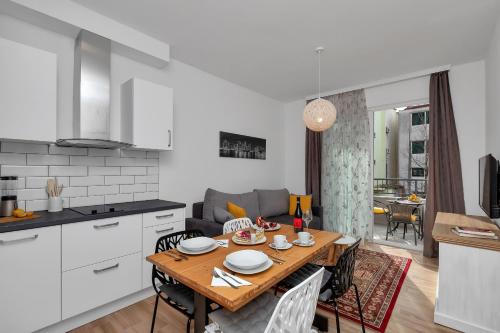 a kitchen and living room with a wooden table and chairs at Emilia Lofts in Tučepi