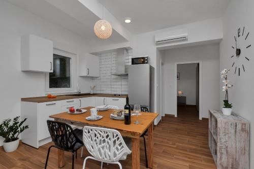 a kitchen and dining room with a wooden table and chairs at Emilia Lofts in Tučepi