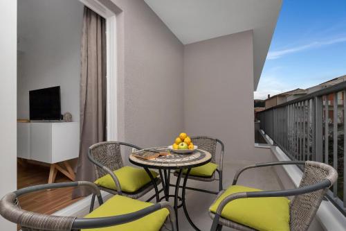 a balcony with a table and chairs and a television at Emilia Lofts in Tučepi