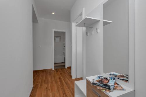 a living room with white walls and wooden floors at Emilia Lofts in Tučepi