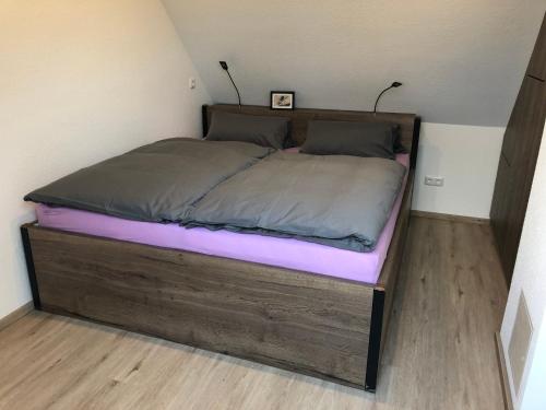 1 cama con marco de madera en una habitación en DOMizil Xanten en Xanten