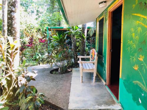 a wooden bench sitting on the porch of a house at Chosa Manglar Suites & Cabins in Puerto Jiménez