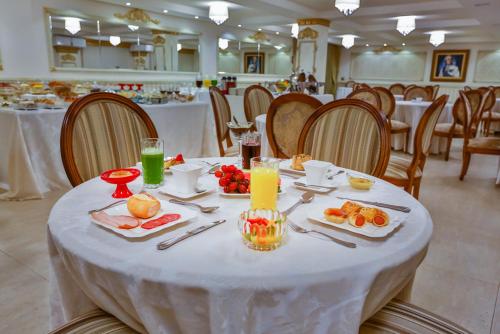 a table with food and drinks on it in a restaurant at Golden Lis Hotel Boutique in Goiânia
