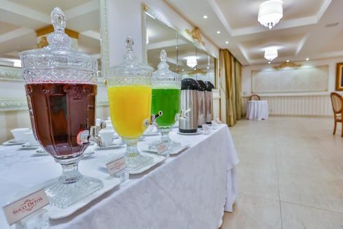 a table with three glasses of different colored drinks on it at Golden Lis Hotel Boutique in Goiânia