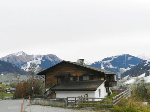 uma casa numa colina com montanhas ao fundo em Apartment Fluehüsli by Interhome em Gstaad