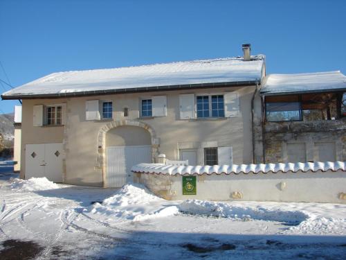 een huis met een garage in de sneeuw bij Gite de l'Ancheronne 12 couchages spa in Lavans-sur-Valouse