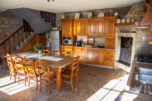 a kitchen with a table and chairs and a staircase at Casa da Tanquinha in Beiral do Lima