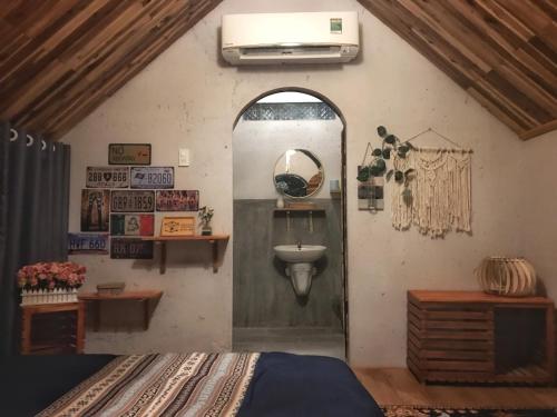 a room with a bed and a sink in it at Phố Đá Hotel in Lagi