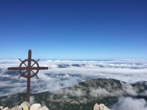 a cross on top of a mountain with clouds at Eau Vive in Lescheraines