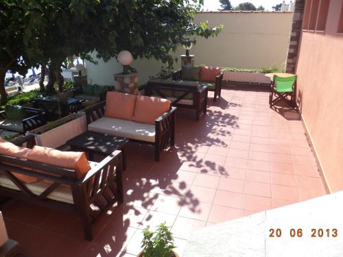 a patio with couches and chairs on a building at Polychrono Beach Hotel in Polykhrono
