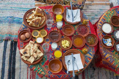a table with plates of food on a table at Imlil Authentic Toubkal Lodge in Imlil
