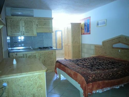 a room with a bed and a kitchen with a counter at Appartamenti Frassanito in Conca Specchiulla